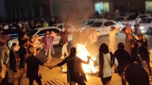 Iranian women dancing around a fire in the context of a protest.